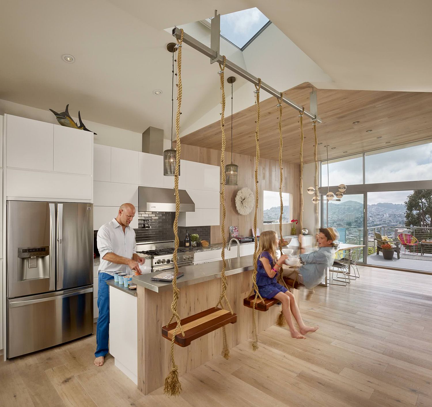 Swing seats suspended from the ceiling along with skylight and lovely views give this kitchen a refreshingly fun appeal
