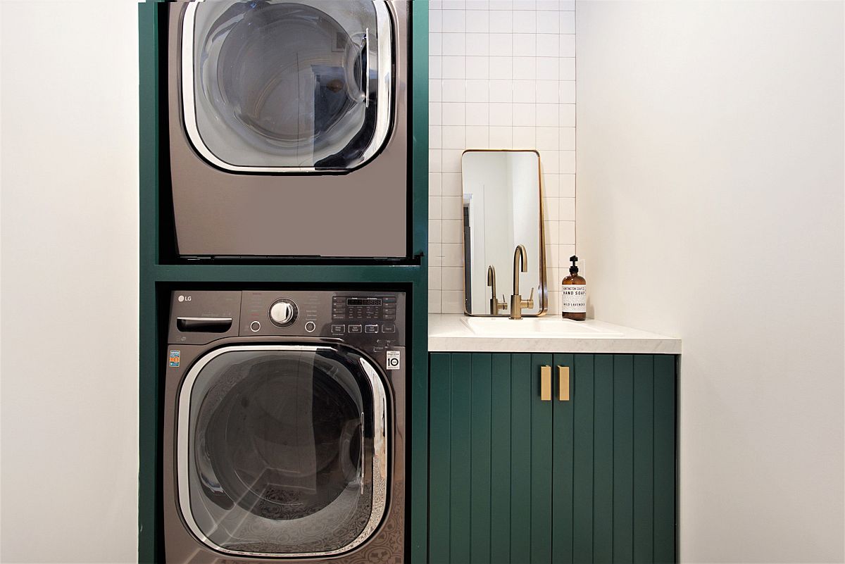 dark green cabinets with gold accents to hold washer and dryer