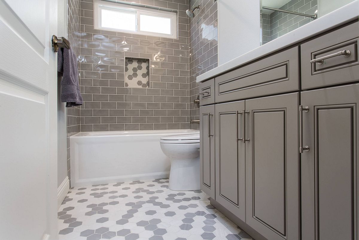 light gray bathroom with white tub and toliet.