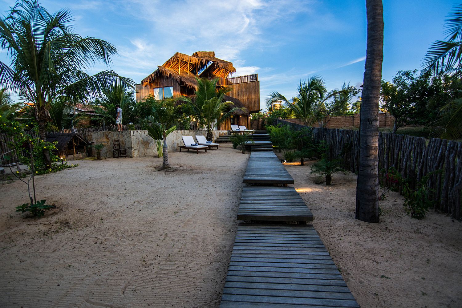 Wooden walkway leads to the summe house with modern beach style