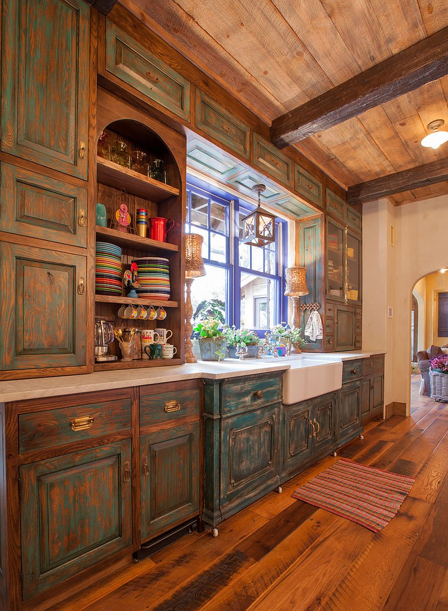 Antique cabinets in wood coupled with blue window frame in the rustc kitchen