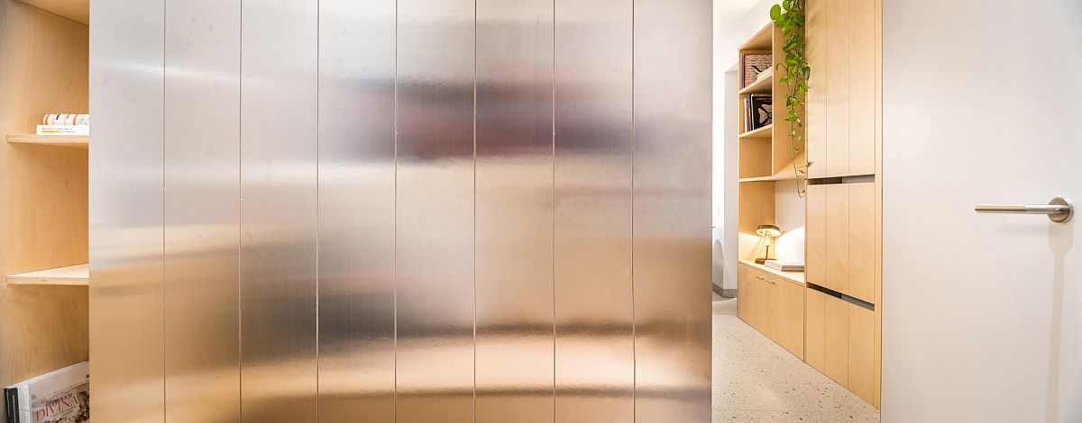 Attractive steel wall cabinet also reflects light inside the apartment