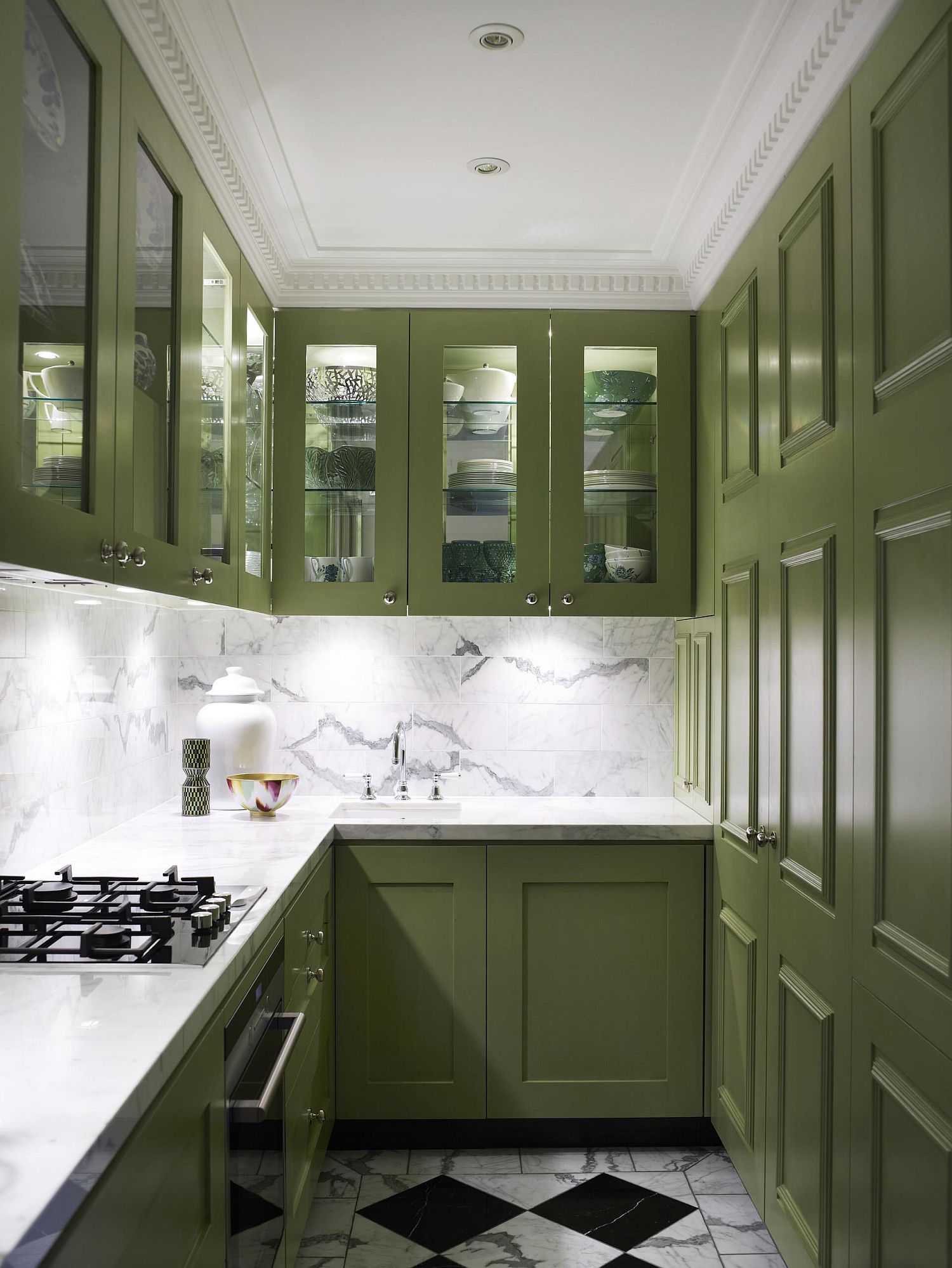 Combining marble with dark green charisma in the narrow, well-lit kitchen