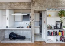 Concrete-and-wood-living-area-of-the-modern-Brazilian-apartment-with-white-shelves-217x155