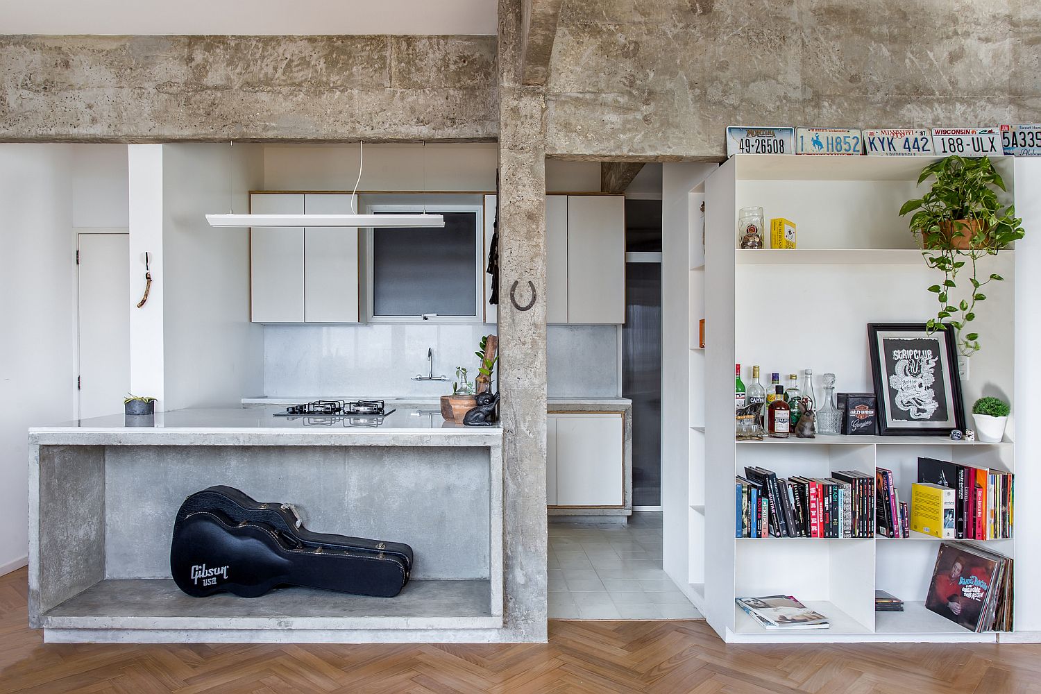 Concrete-and-wood-living-area-of-the-modern-Brazilian-apartment-with-white-shelves