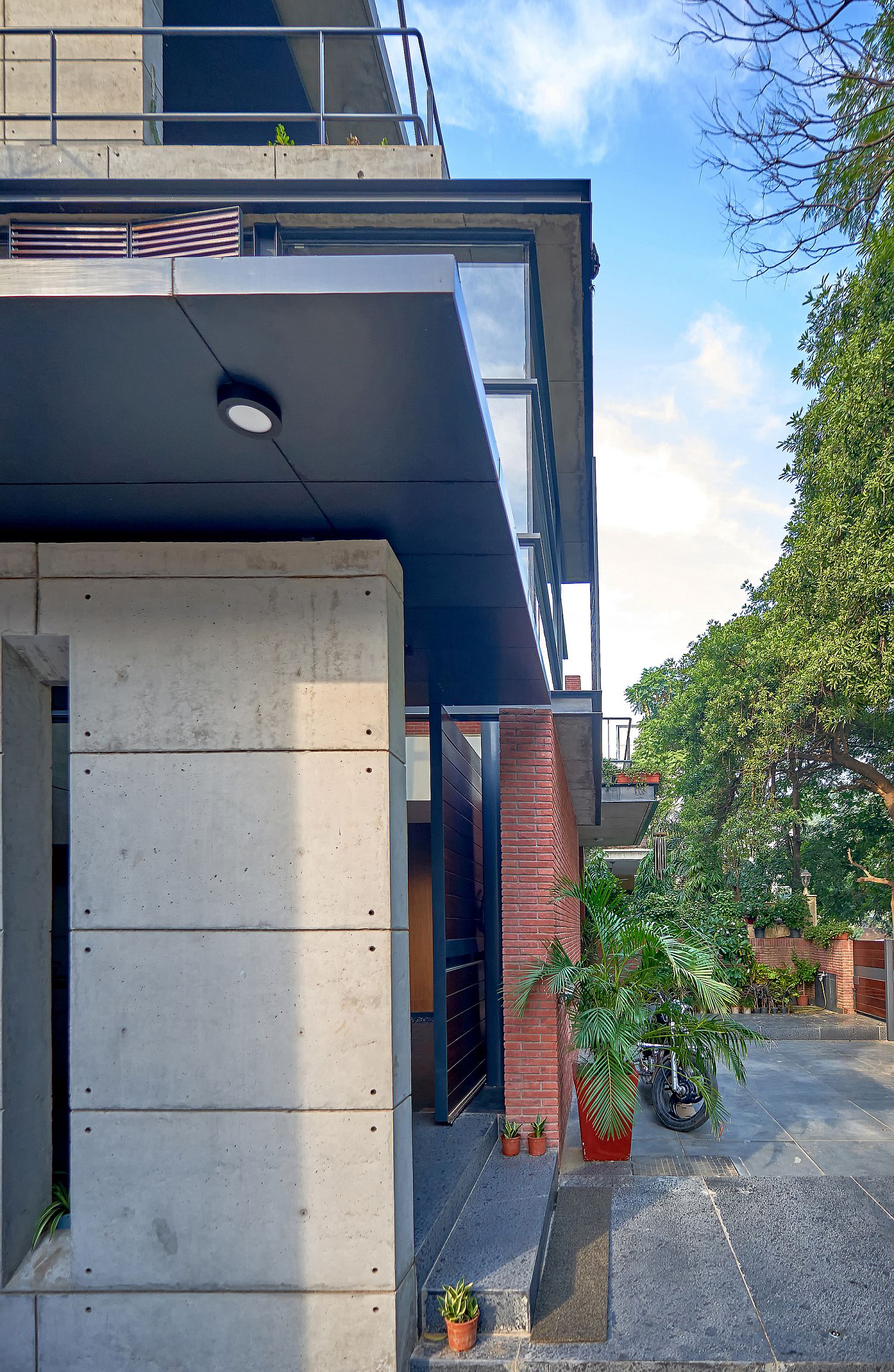 Concrete provides a sturdy base for the glass and brick office in India