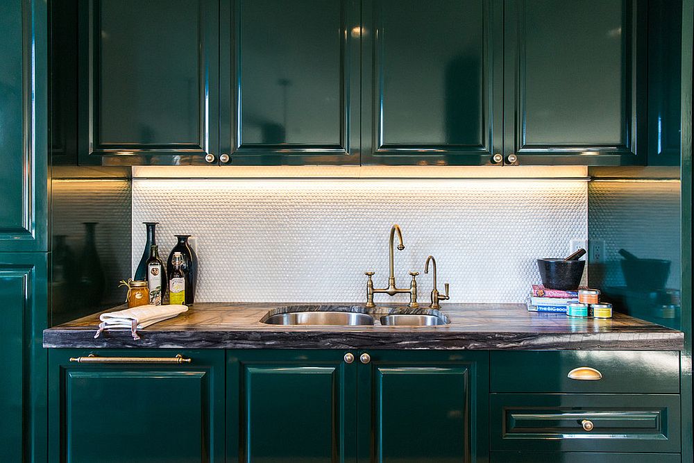 Deep dark green cabinets coupled with shiny penny tile backsplash in the kitchen