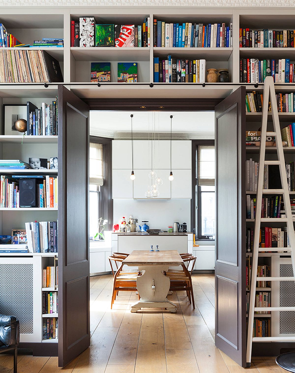 Doorway with built-in shelves around it delineates the kitchen and the doorway