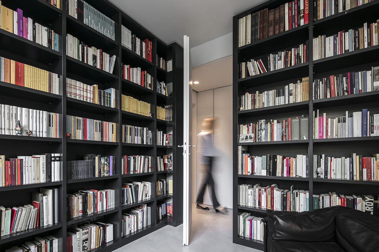 Home library with wall shelves all around that offer plenty of storage space