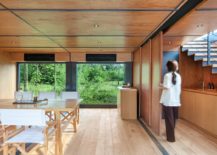 Lower-level-of-the-marketing-suite-with-dining-area-and-kitchen-draped-in-wood-217x155