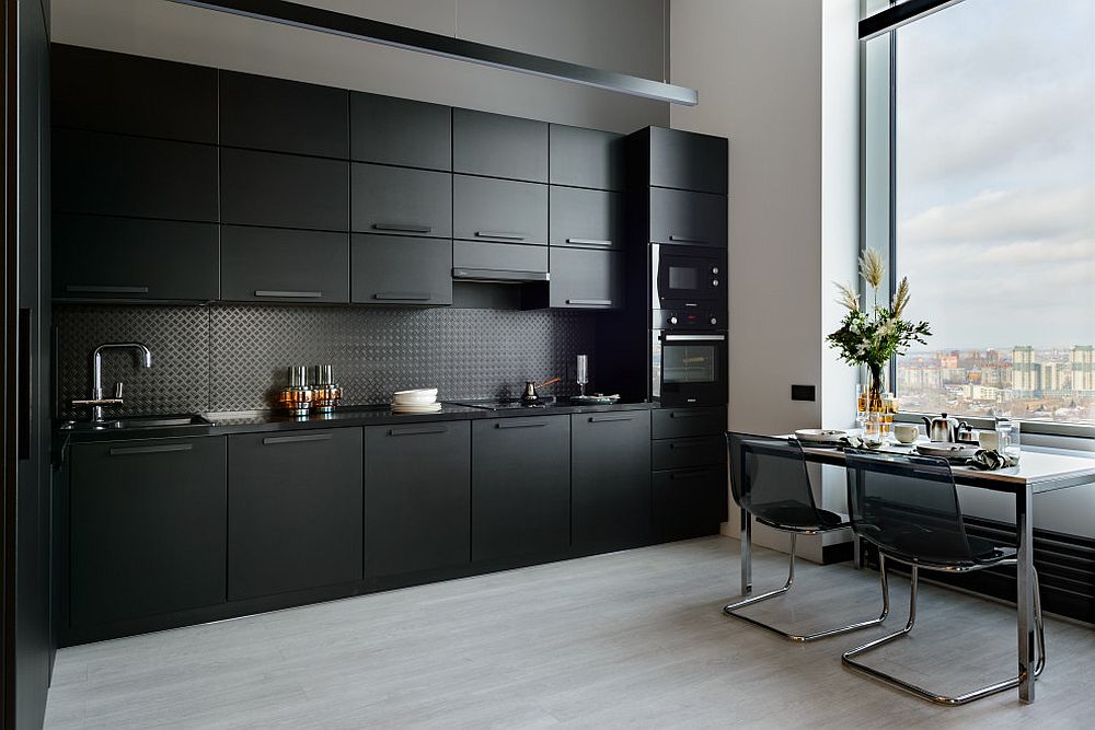 Single-wall-kitchen-in-black-with-dining-space-next-to-it-and-a-large-window-tha-ushers-in-the-view