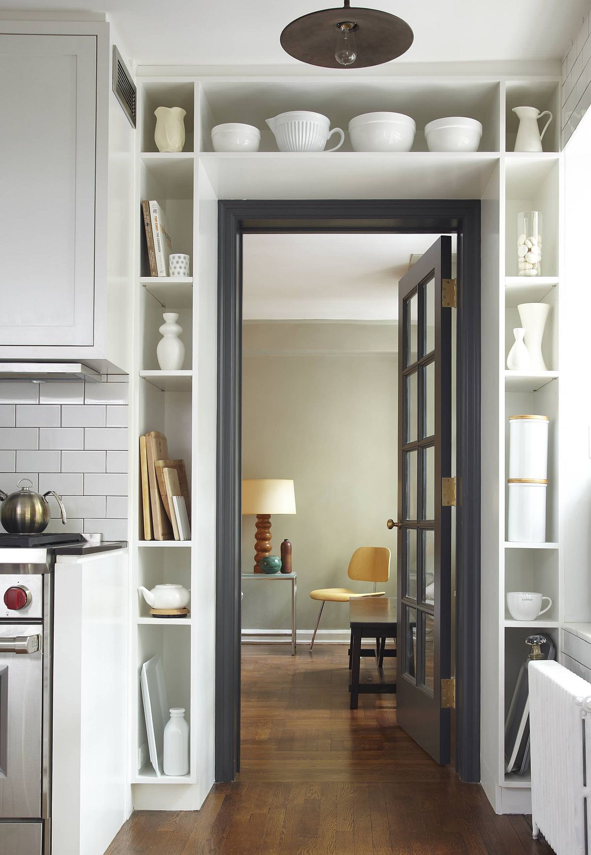 Slim and open shelves around the doorway in the kitchen offer some much needed storage space