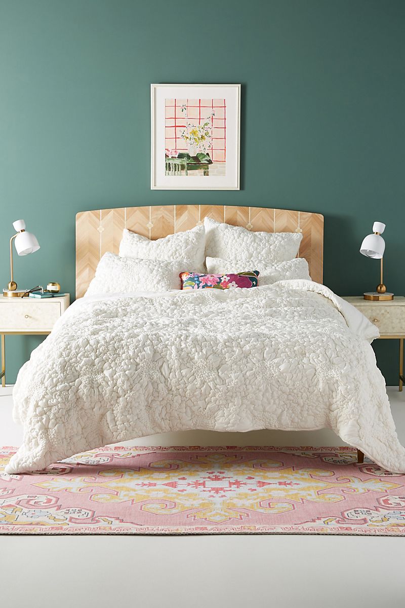 Textured-bedding-against-a-mossy-green-accent-wall