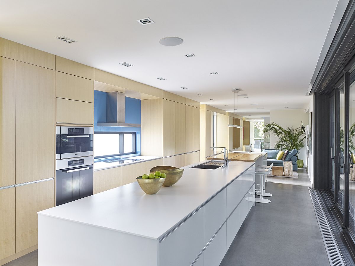 Wood-and-white-kitchen-of-the-house-with-sliding-glass-doors-that-usher-in-ample-light