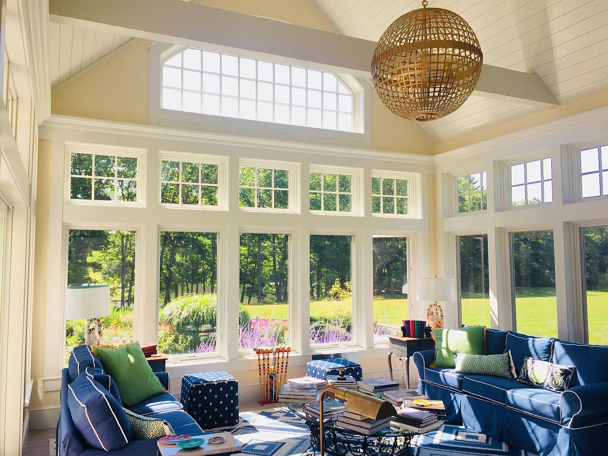 Beautiful influx of blue in the spacious and traditional sunroom of Boston home using couch and club chairs