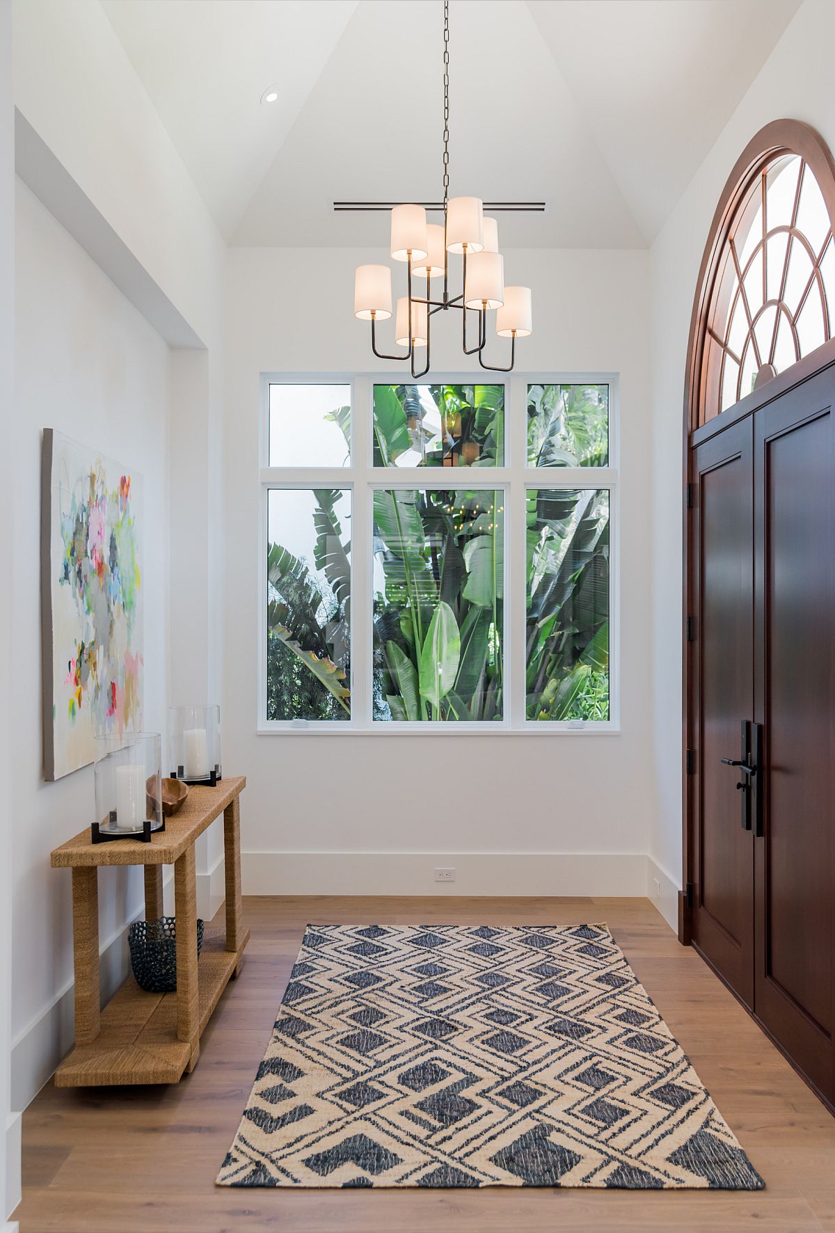 Beautiful white entry with high ceiling and a simple console table in wood