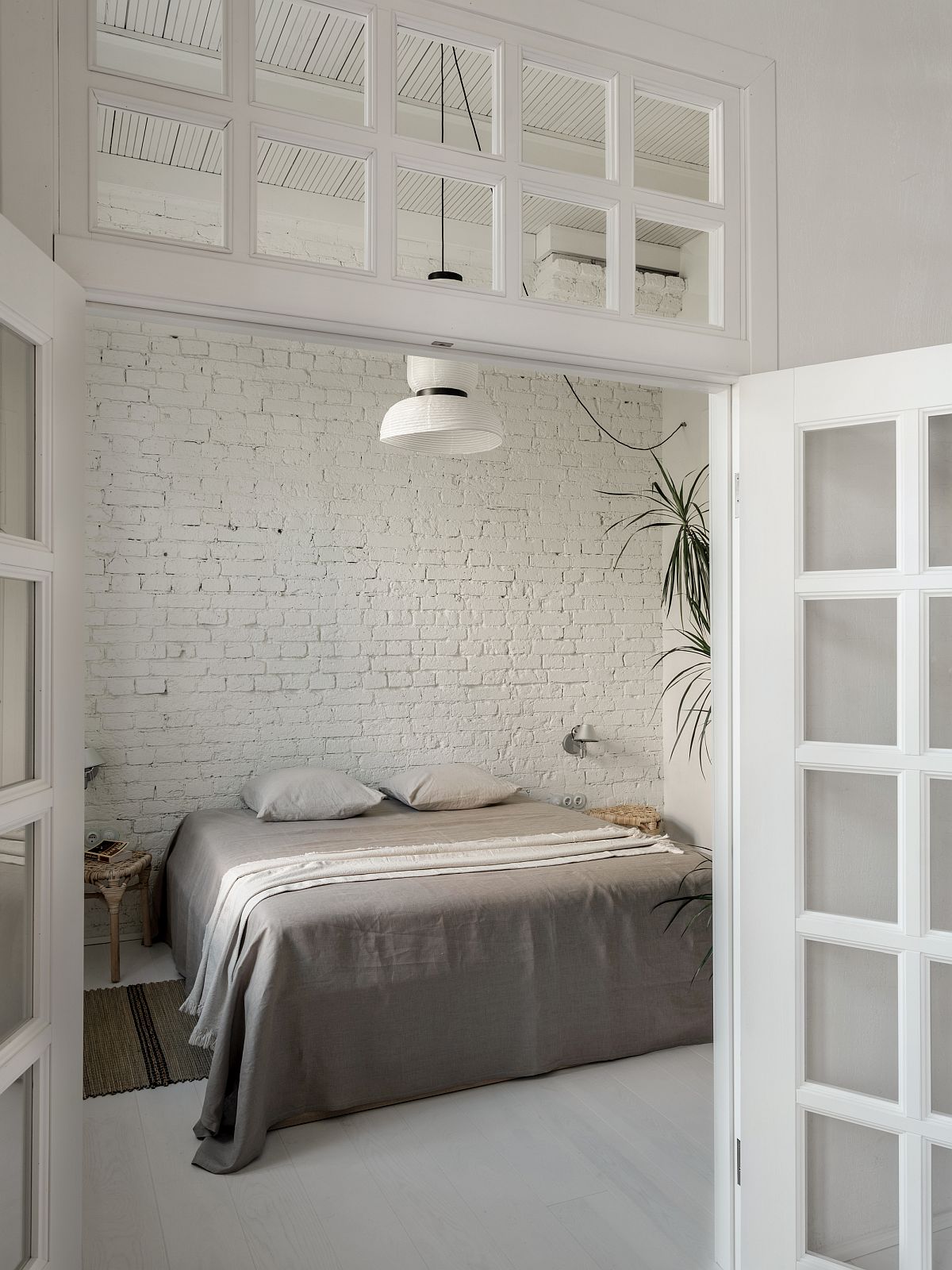Bedroom of the Moscow apartment in white has a serene Scandinavian style about it