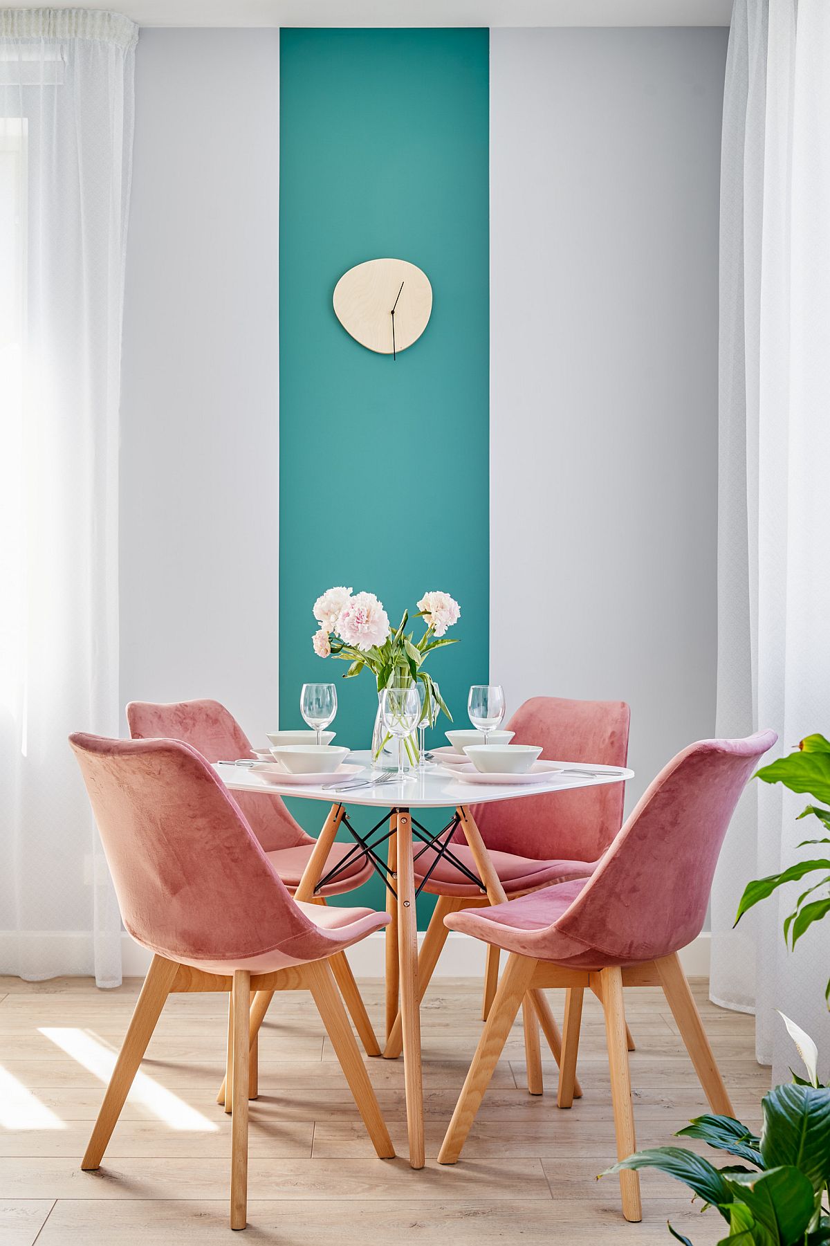 Chairs around the dining table and the backdrop add color to the dining room