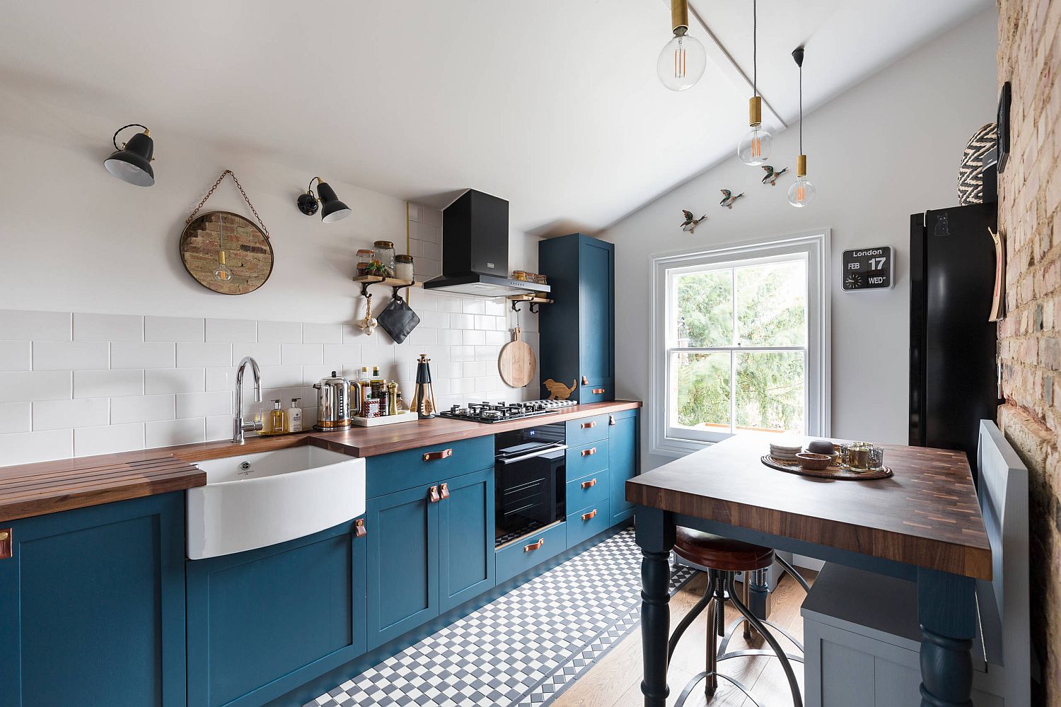 Classy-light-filled-kitchen-with-blue-cabinets-and-appliances-in-black-58204