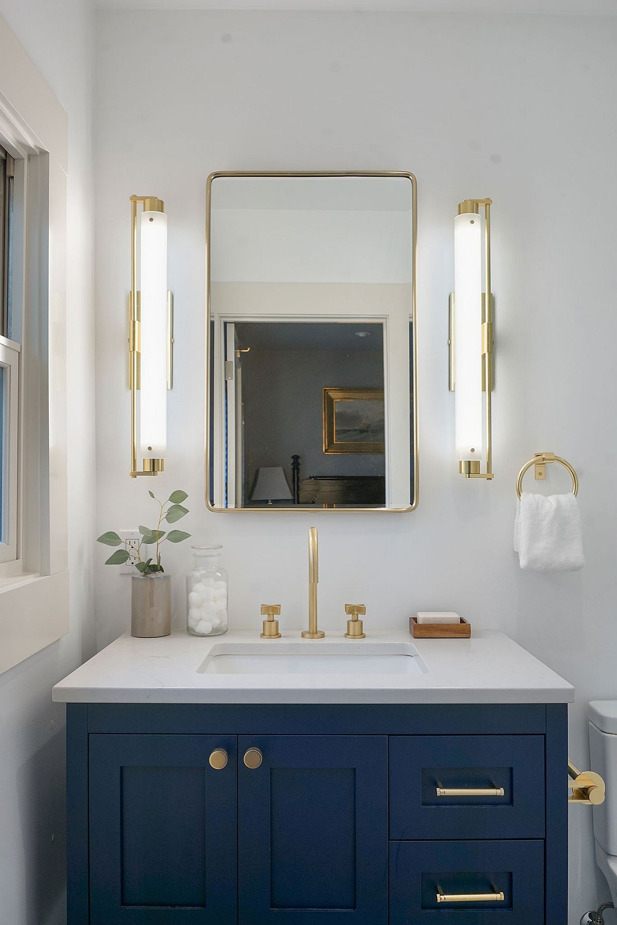 Combining gold accents with the dashing blue vanity in the modern bathroom