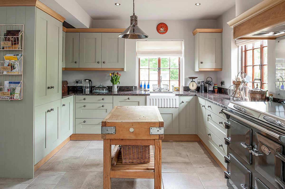 Custom butcher block island stands in the middle of the lovely farmhouse style kitchen with granite countertops