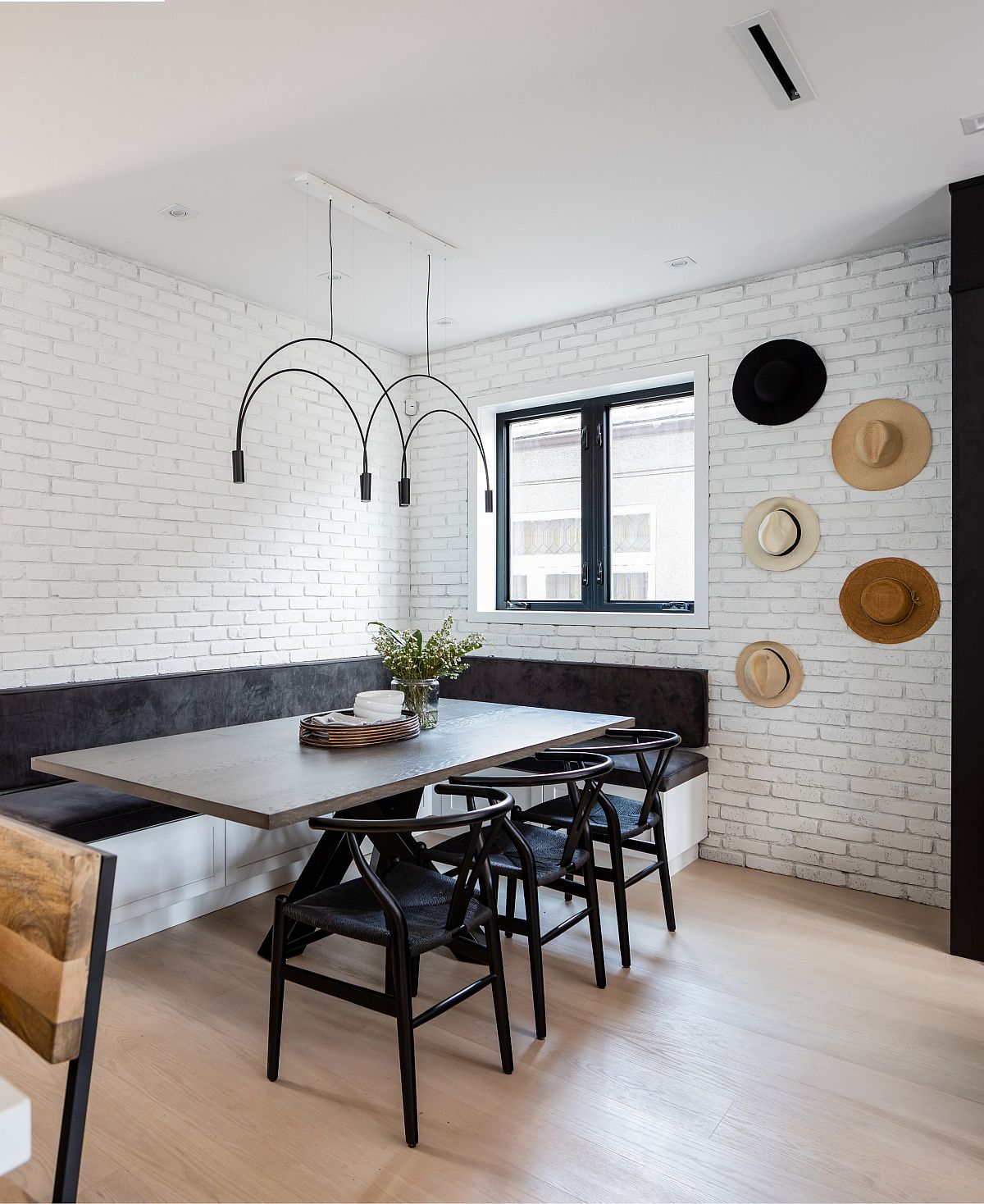 Custom corner banquette seat coupled with stylish chairs bring black to the dining room