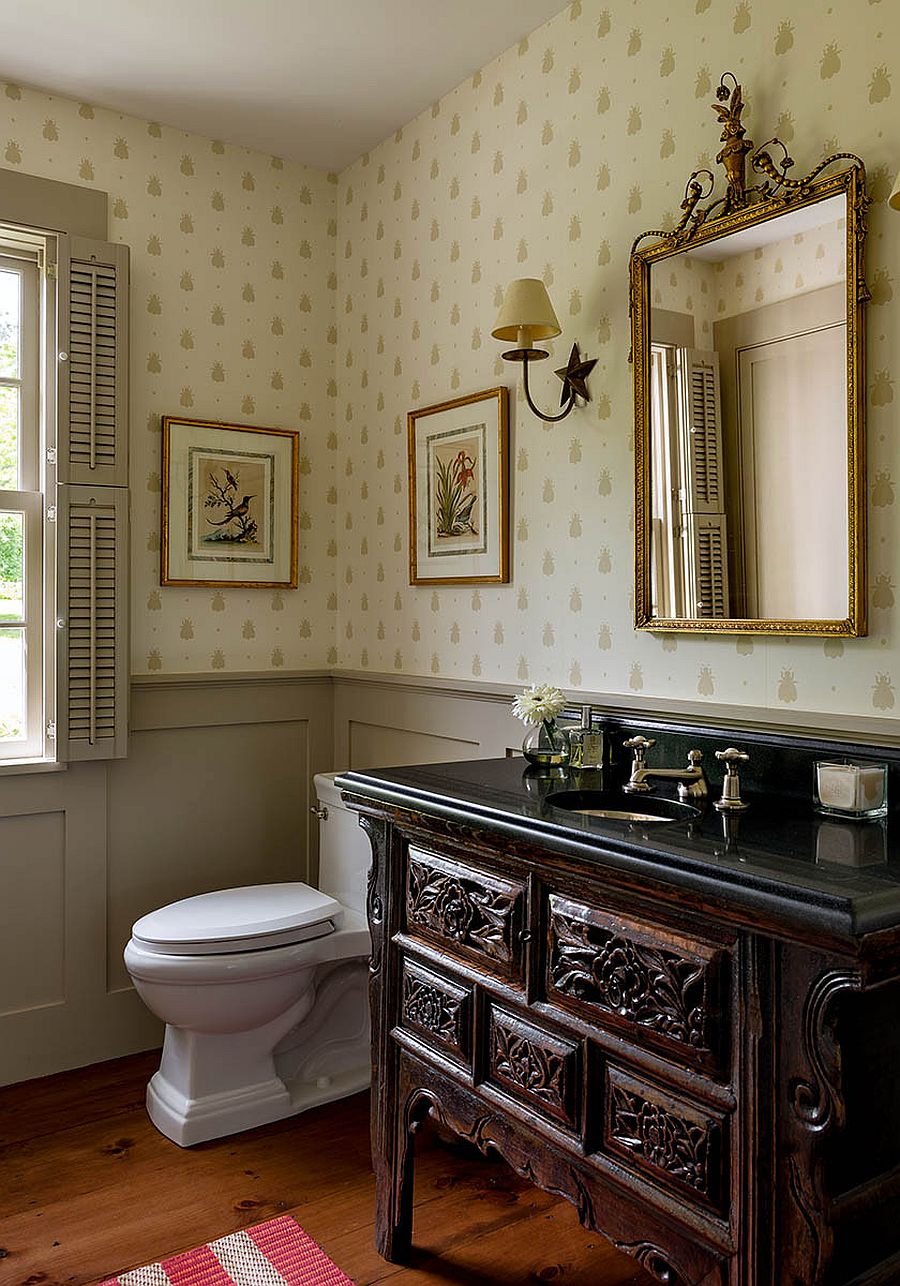 Custom wooden vanity and walls draped in beautiful wallpaper for the spacious farmhouse style powder room