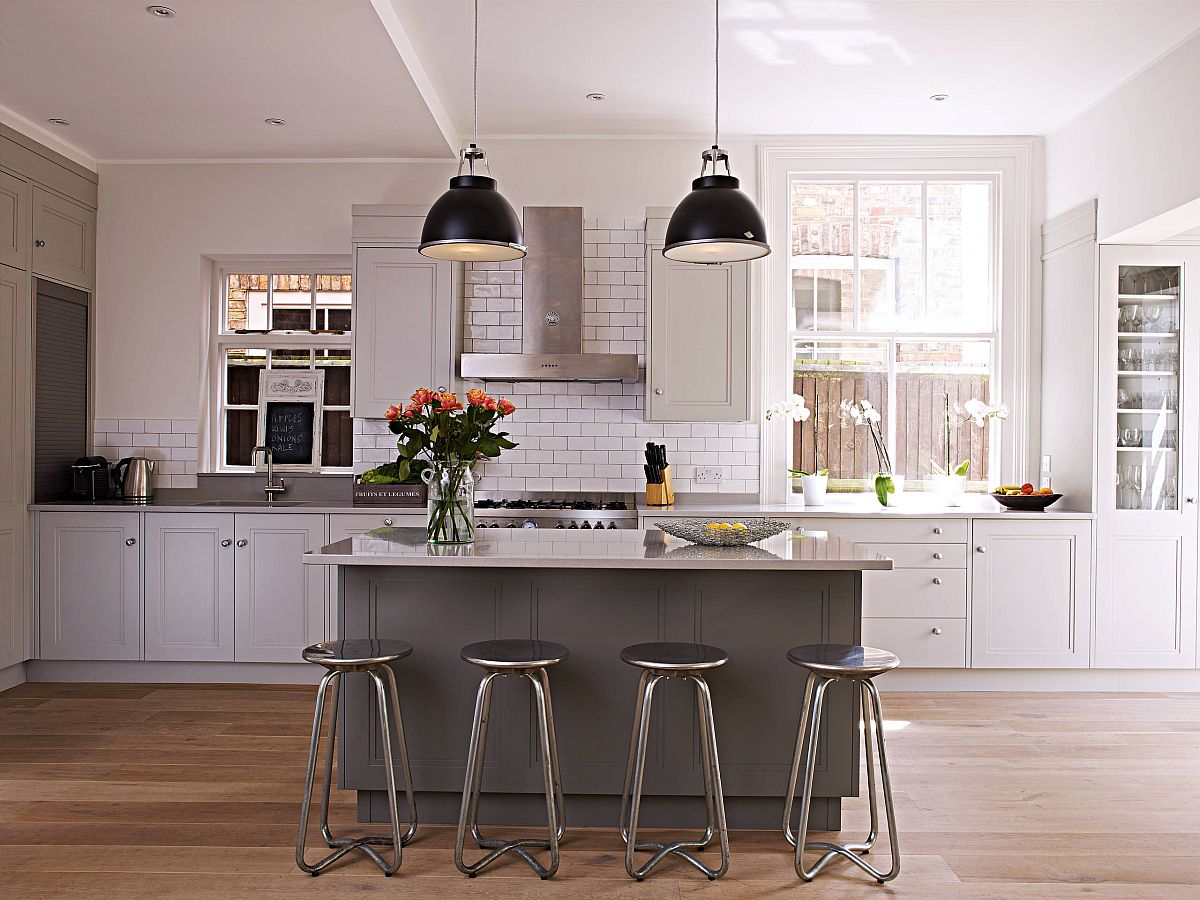 Dark pendants add contrast to the kitchen while the wooden floors provide visual warmth