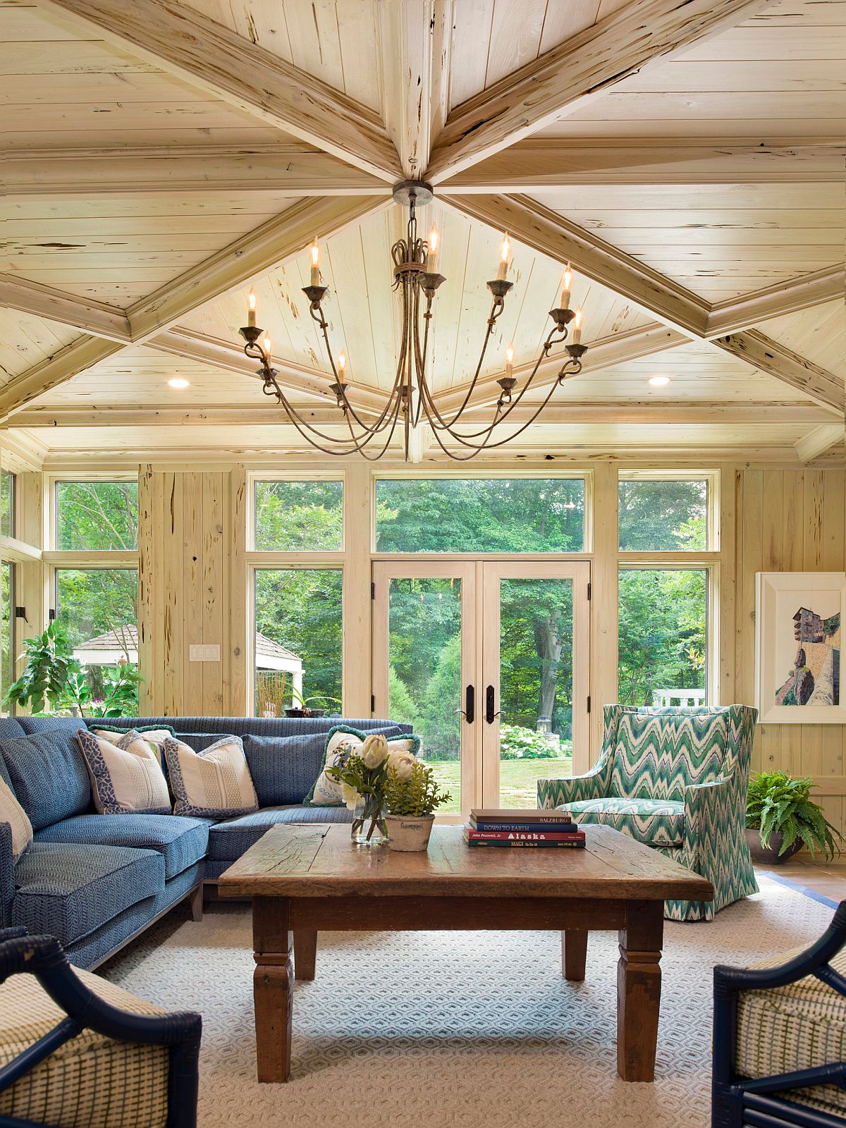 Dashing traditional sunroom with woodsy walls and ceiling where the sofa brings in a splash of blue