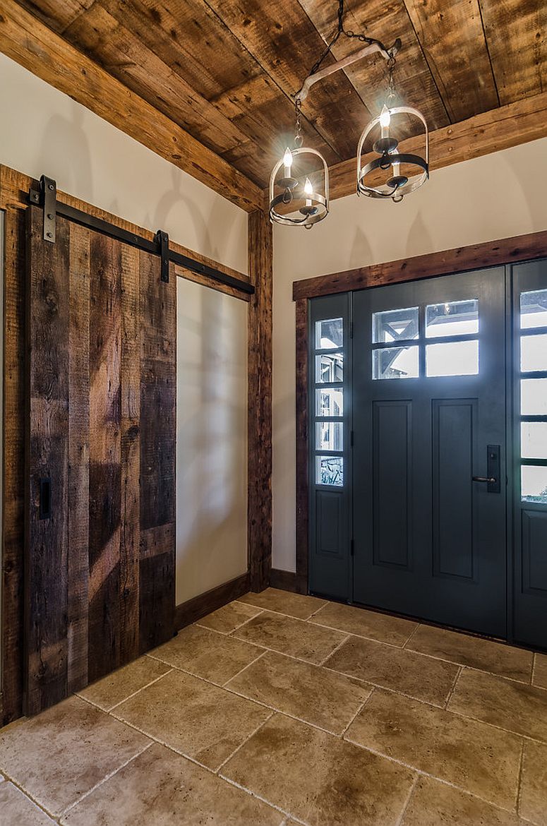 Door in blue adds color to the entry space in white with reclaimed wood wall section