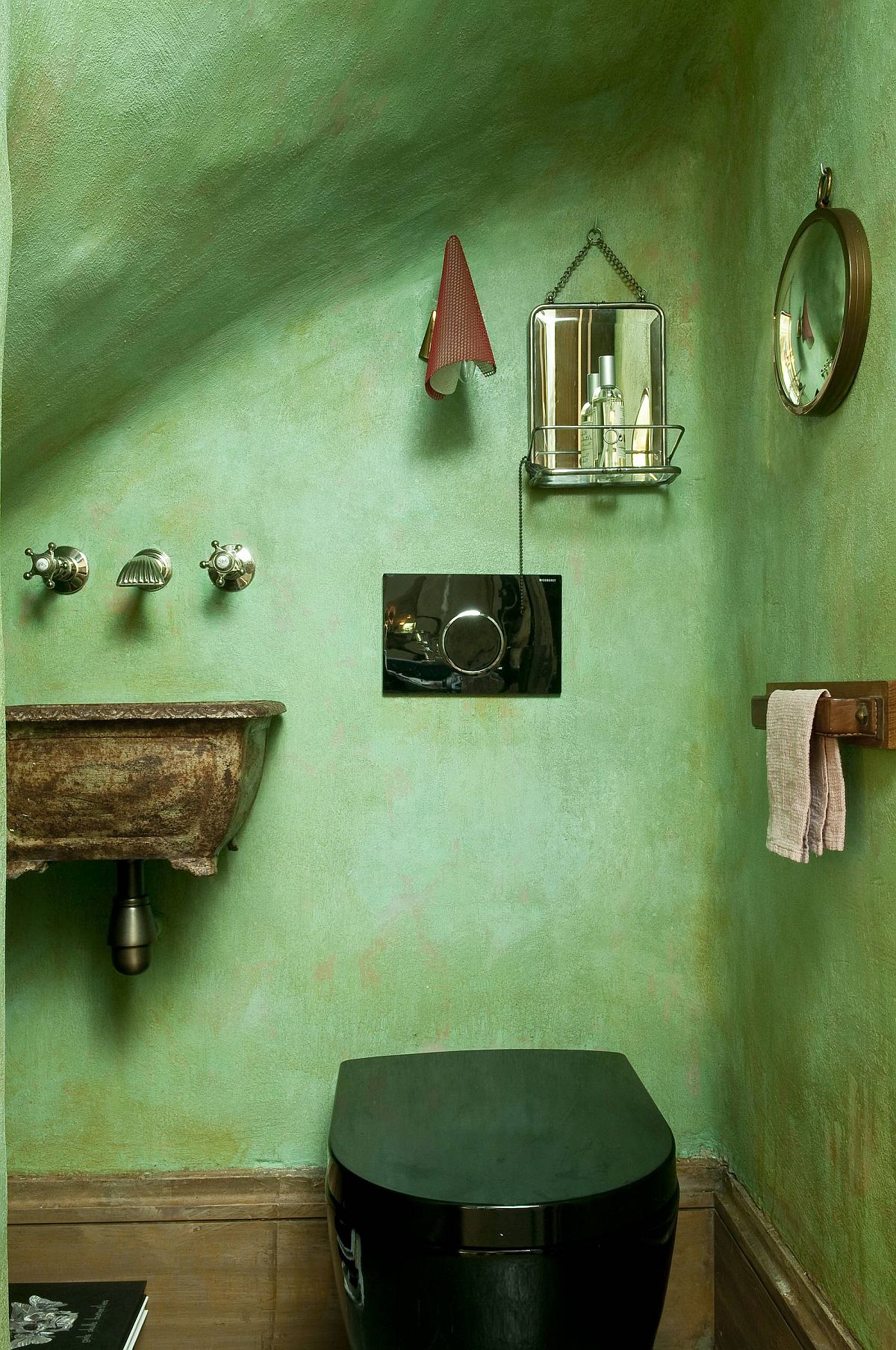 Eclectic powder room of the Paris home with textured walls in green