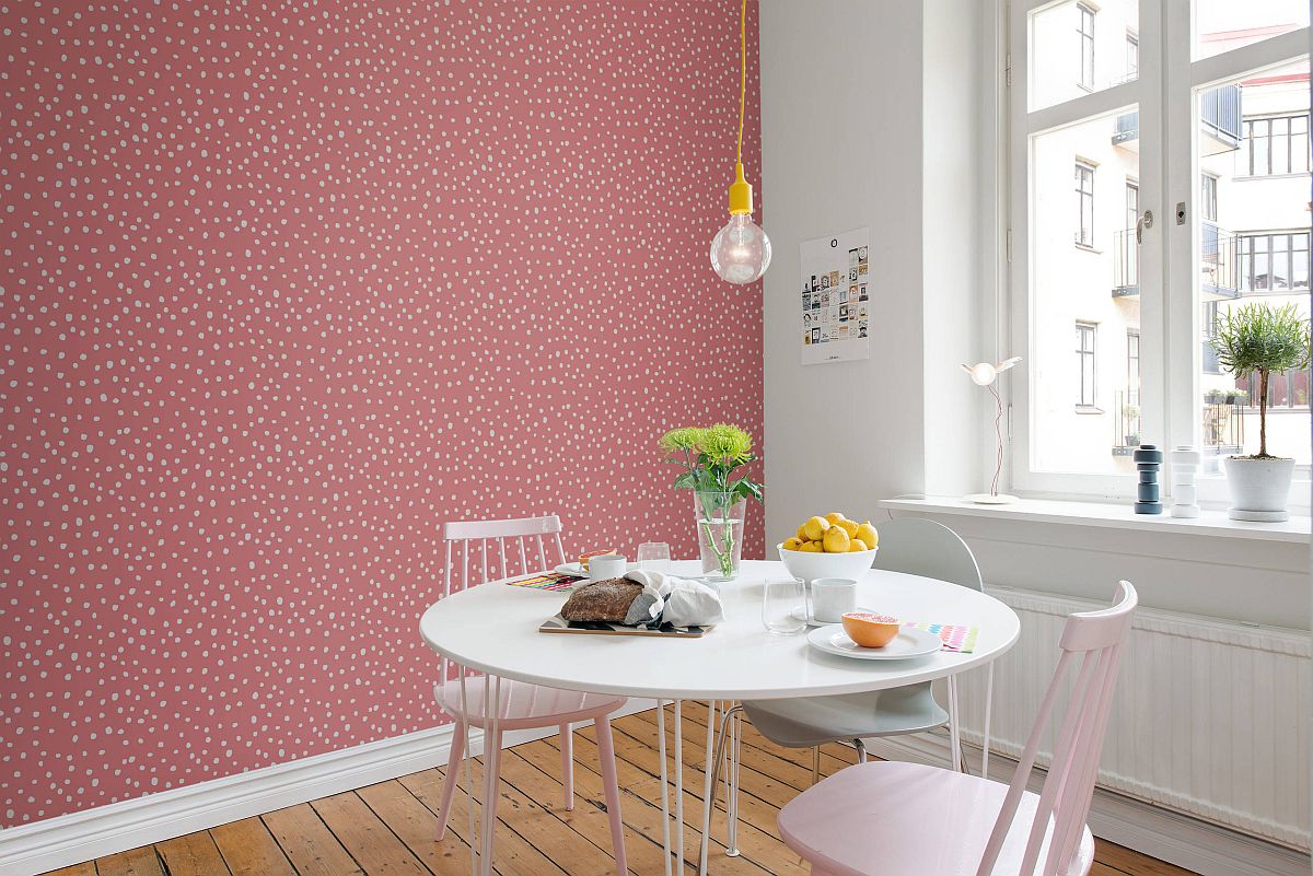 Eye-catching pink accent wall for the dining room with simple Edison bulb lighting