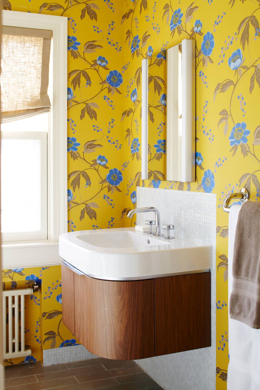 Eye-catching yellow wallpaper with bright blue pops inside the powder room