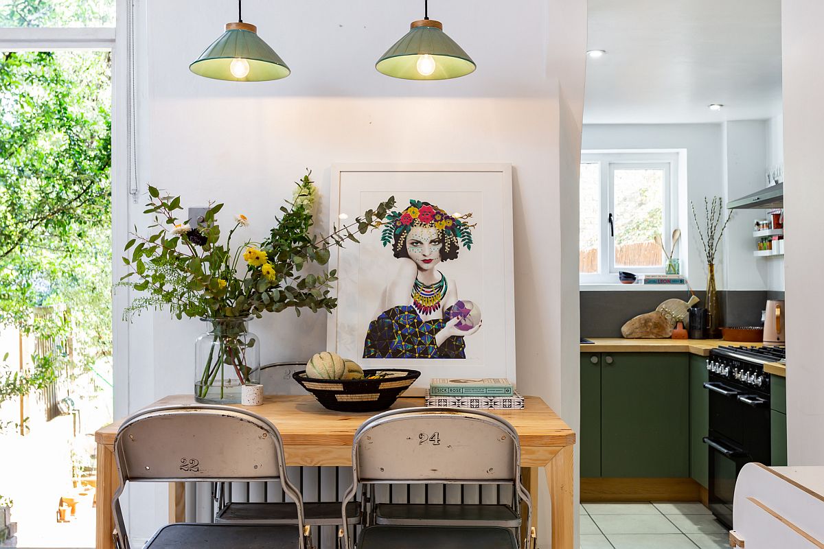 Green accents in the small living room create visual connectivity with the kitchen behind it