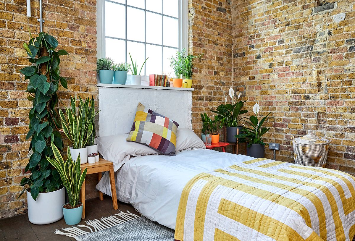 Industrial bedroom with brick walls and indoor plants feels refreshing and relaxing