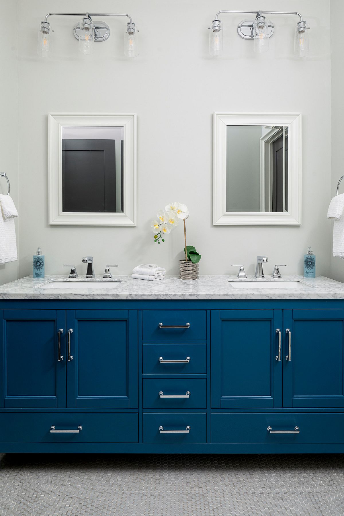 Large Classic Blue vanity with marble countertop steals the show in this modern white bathroom