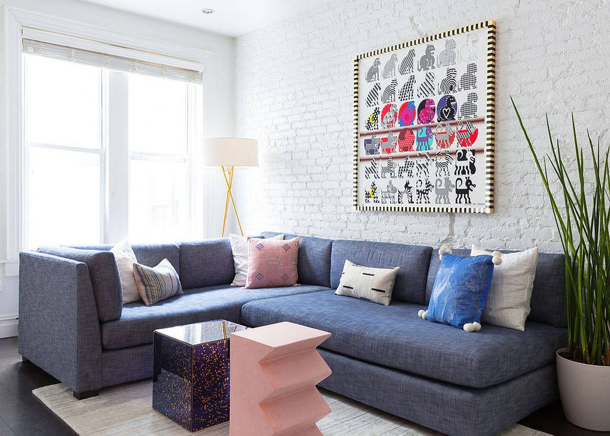 Large bluish-gray sectional for the white living room with painted brick wall