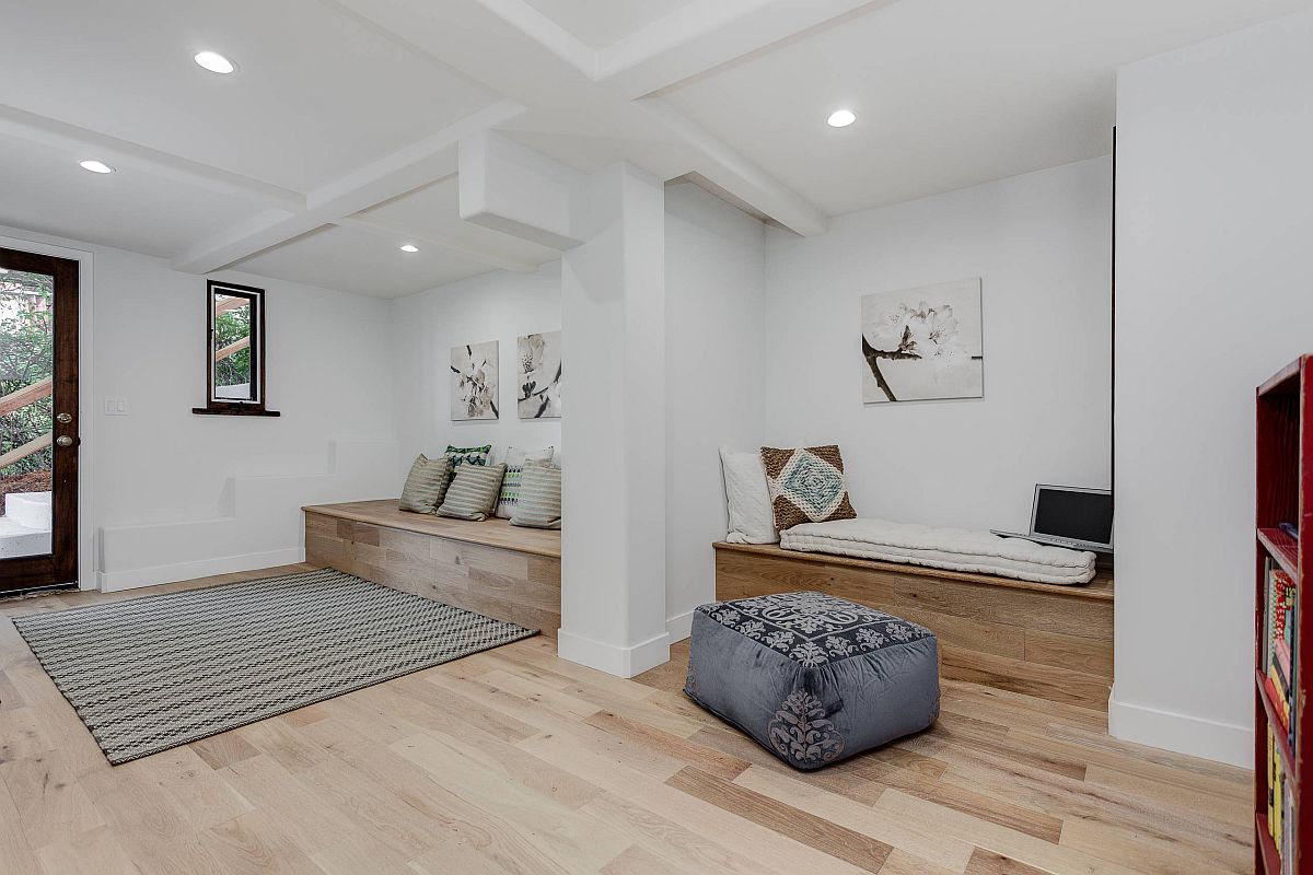 Light wood floors and custom benches coupled with white walls inside the entry of LA home