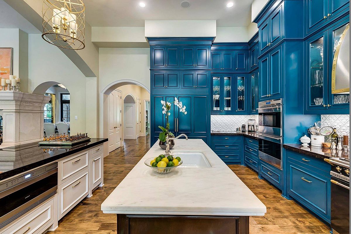 Lovely wood floor adds textural charm and pattern to the kitchen with blue cabinets