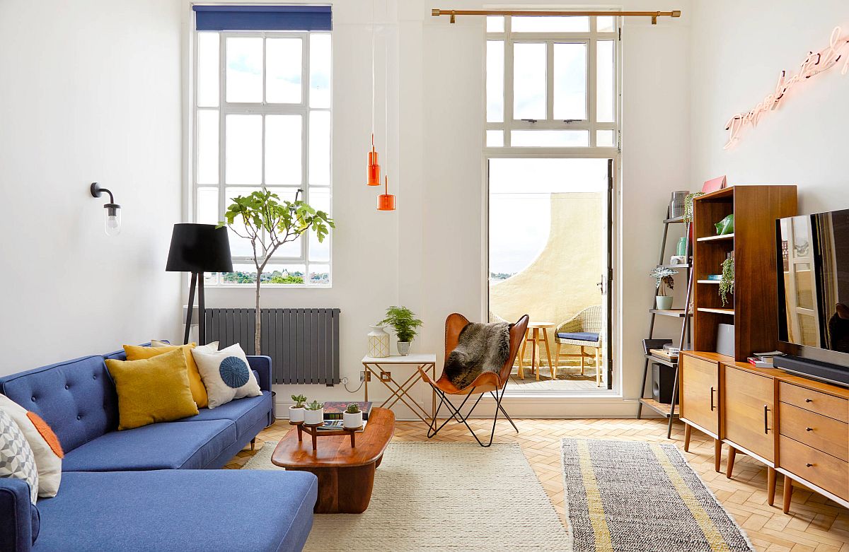 Midcentury modern living room with a bright blu couchand pops of orange all around