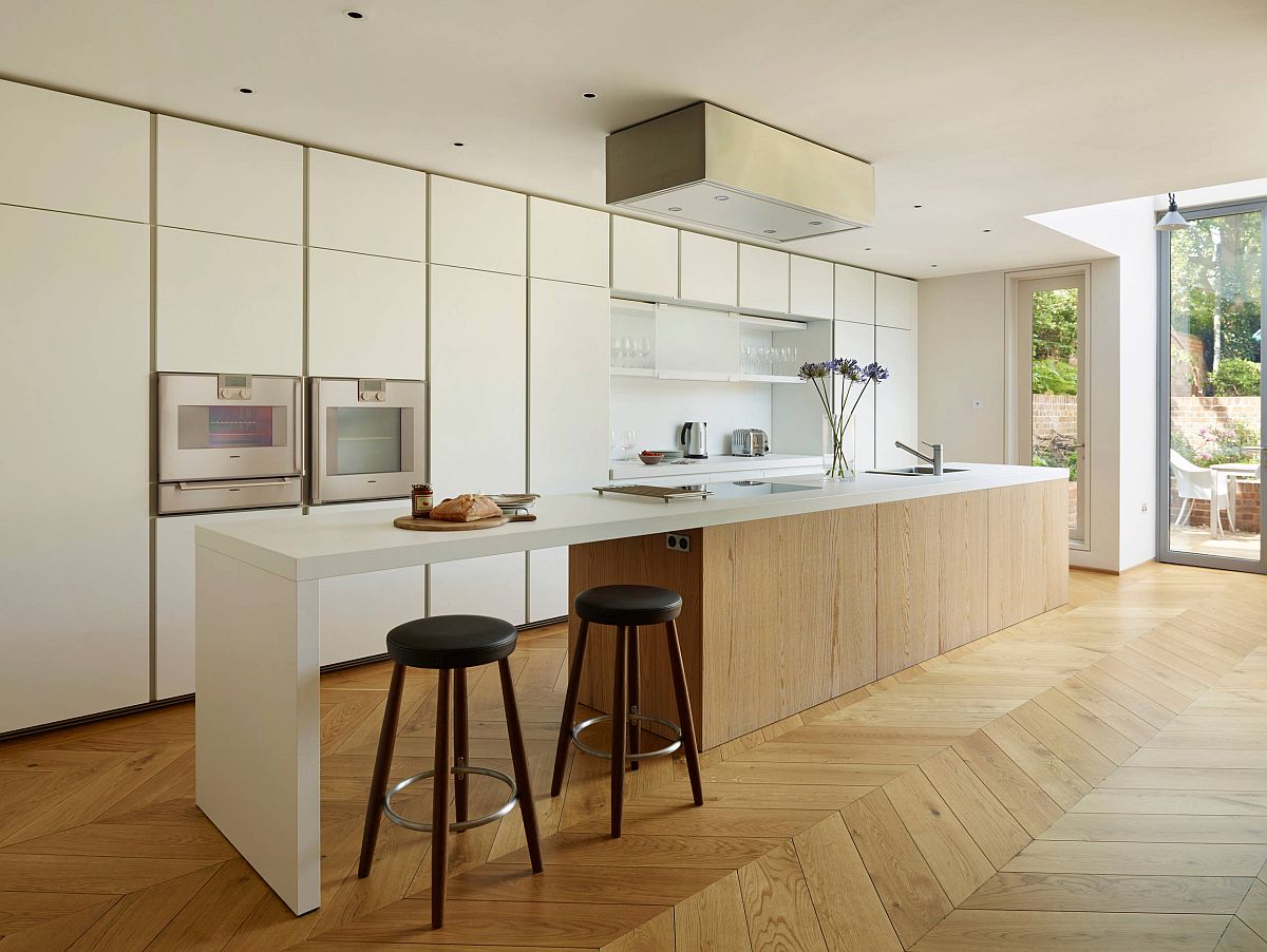 Modern classic kitchen of London home with cozy wooden floor and white walls and cabinets