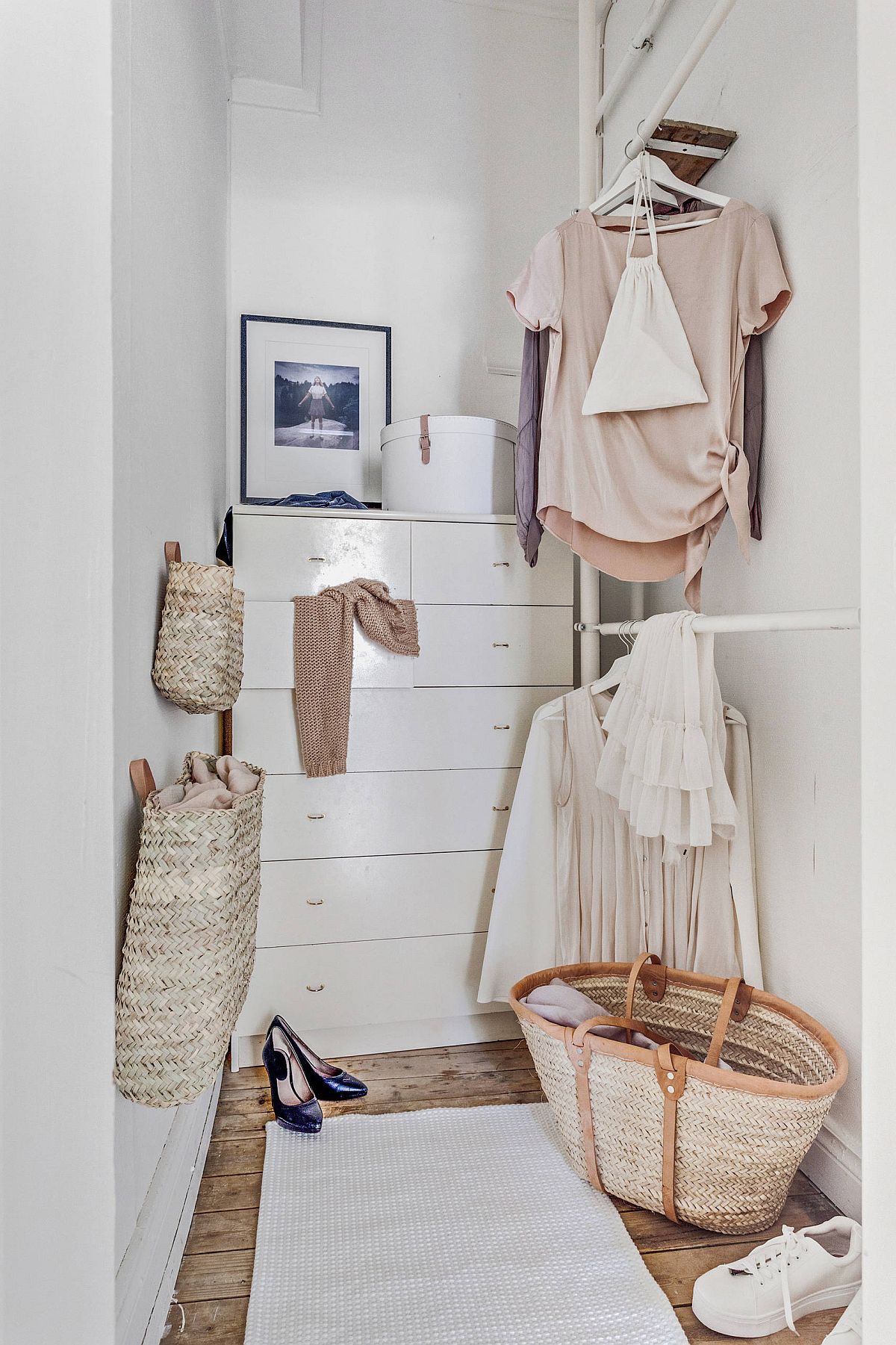 Neatly designed white cabinets and baskets create ample storage space in this wardrobe niche