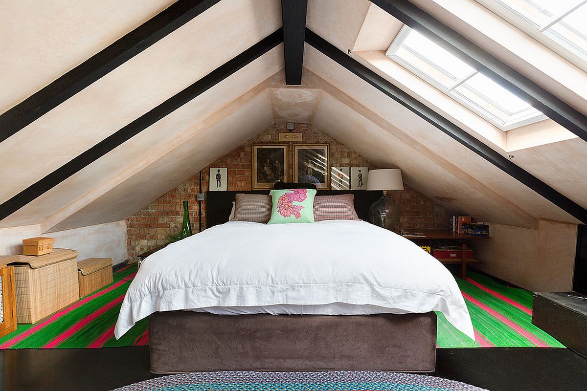 Skylights bring plenty of natural light ino this space-savvy attic bedroom with ceiling beams