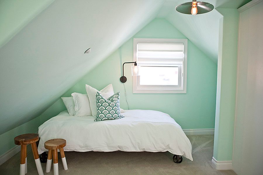 Tiny attic bedroom in pastel green also serves as a great guest room when needed