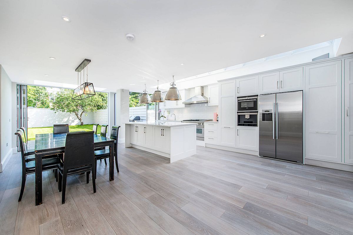 Transitional style kitchen with gorgeous wooden floor, ample naural lighting and dining space