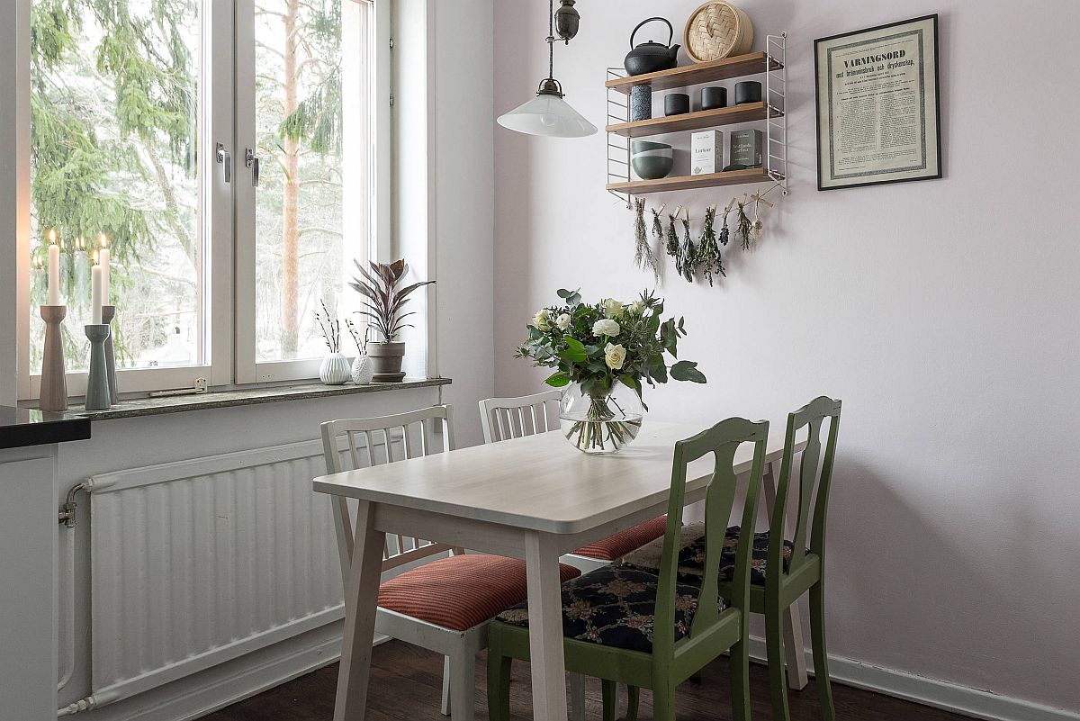 Twin chairs add green glam to the white dining area