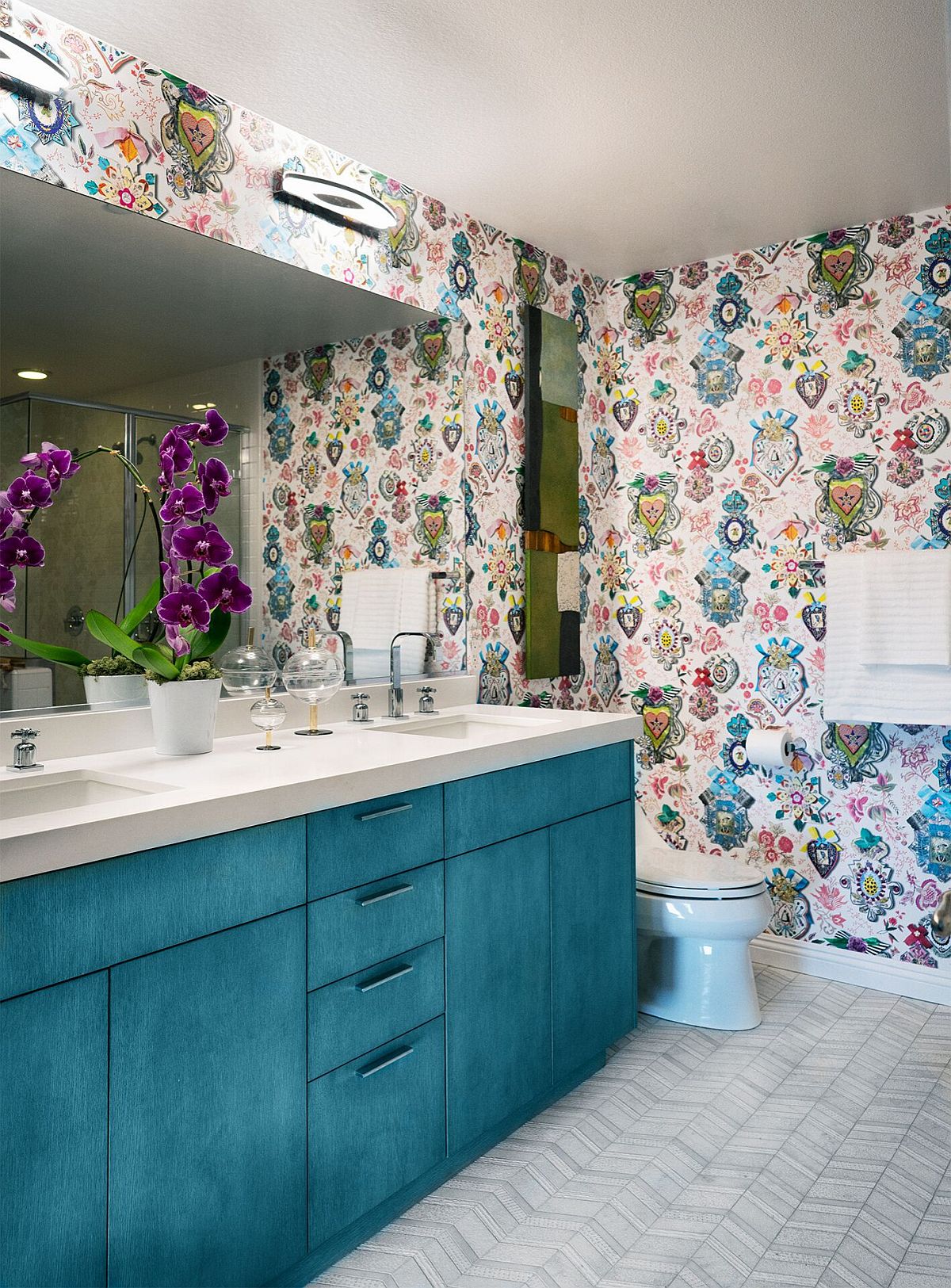 Unique shade of blue for the bathroom vanity coupled with lively wallpapered backdrop