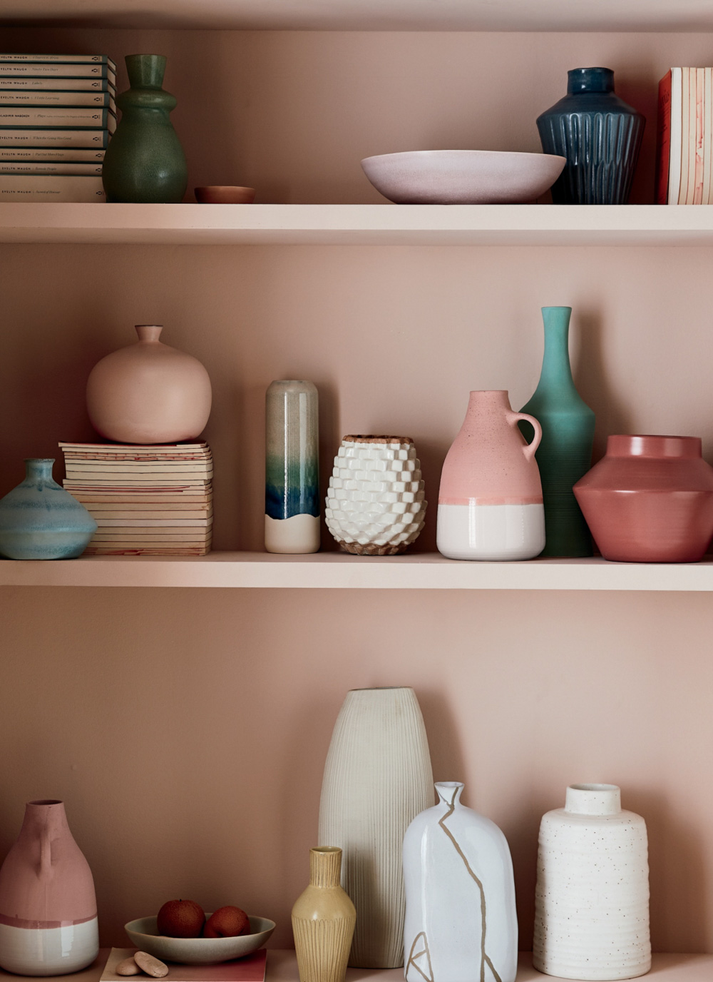 A collection of vases against a dusty pink backdrop