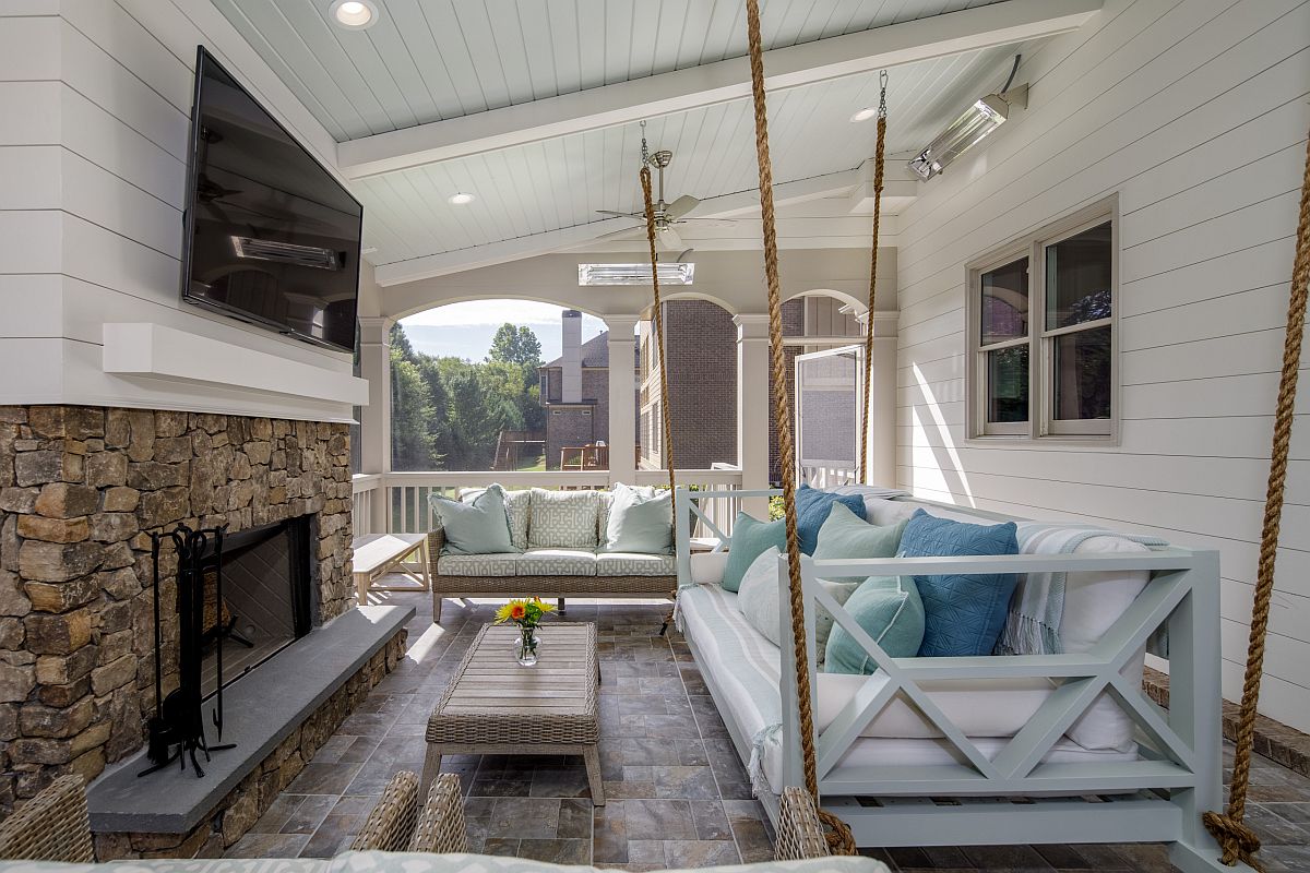 Accent pillows bring different shades of blue to the spacious and stylish porch