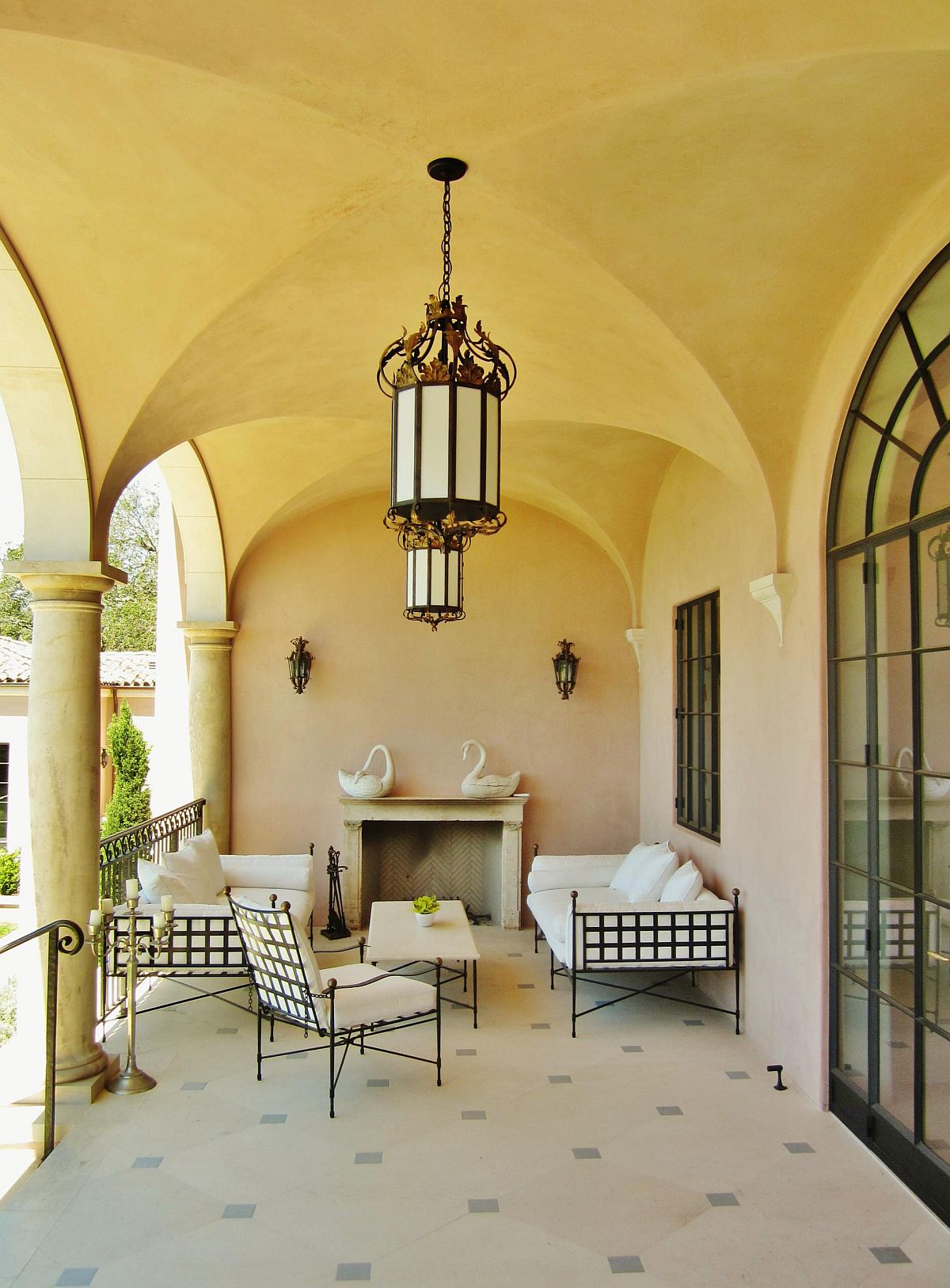 Arches, plastered walls and a warm yellow glow bring unmistakable Mediterranean vibe to this porch